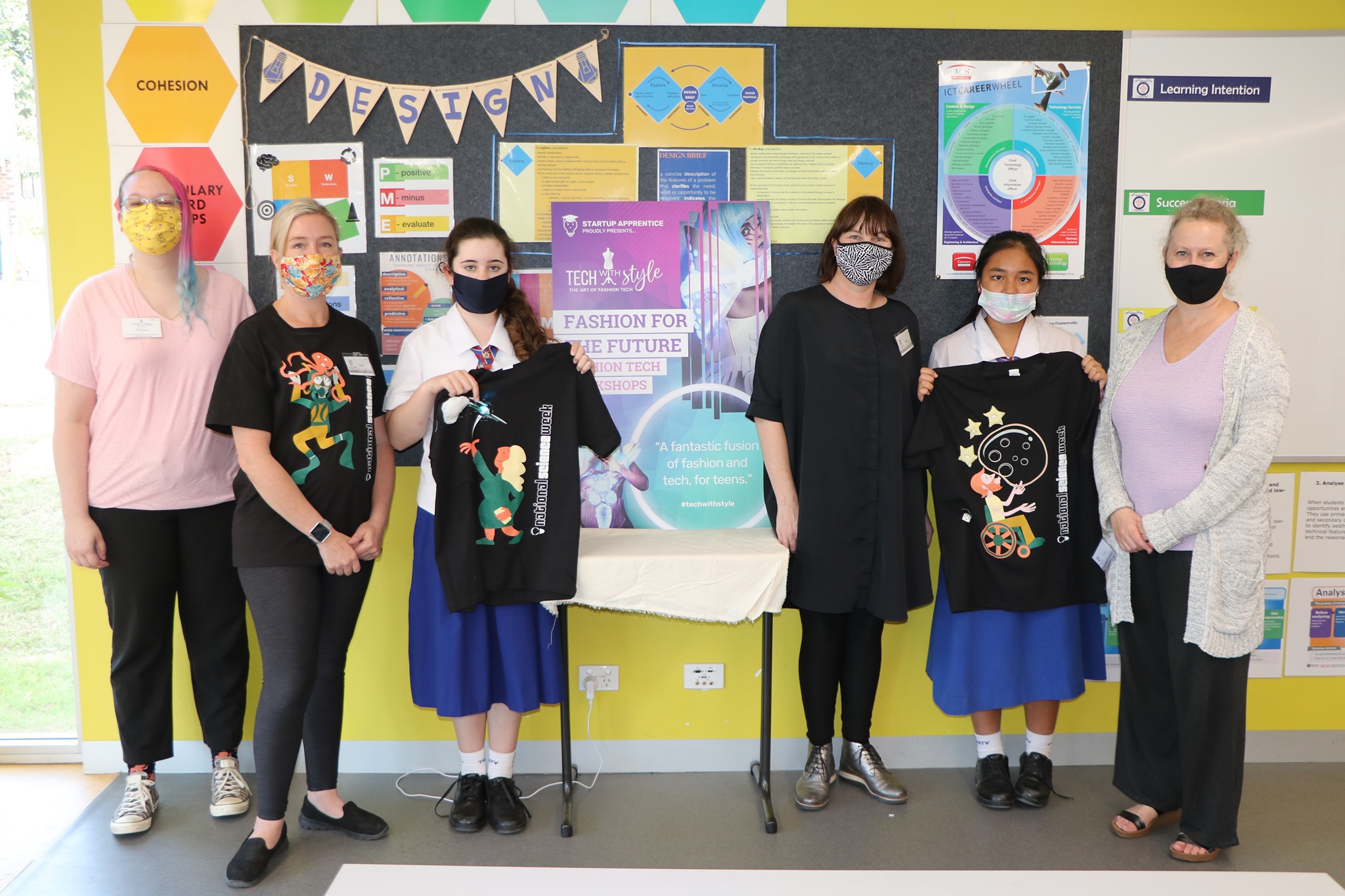 Students and staff presenting student designed garments during a technology and fashion learning activity promoting creativity collaboration and design skills
