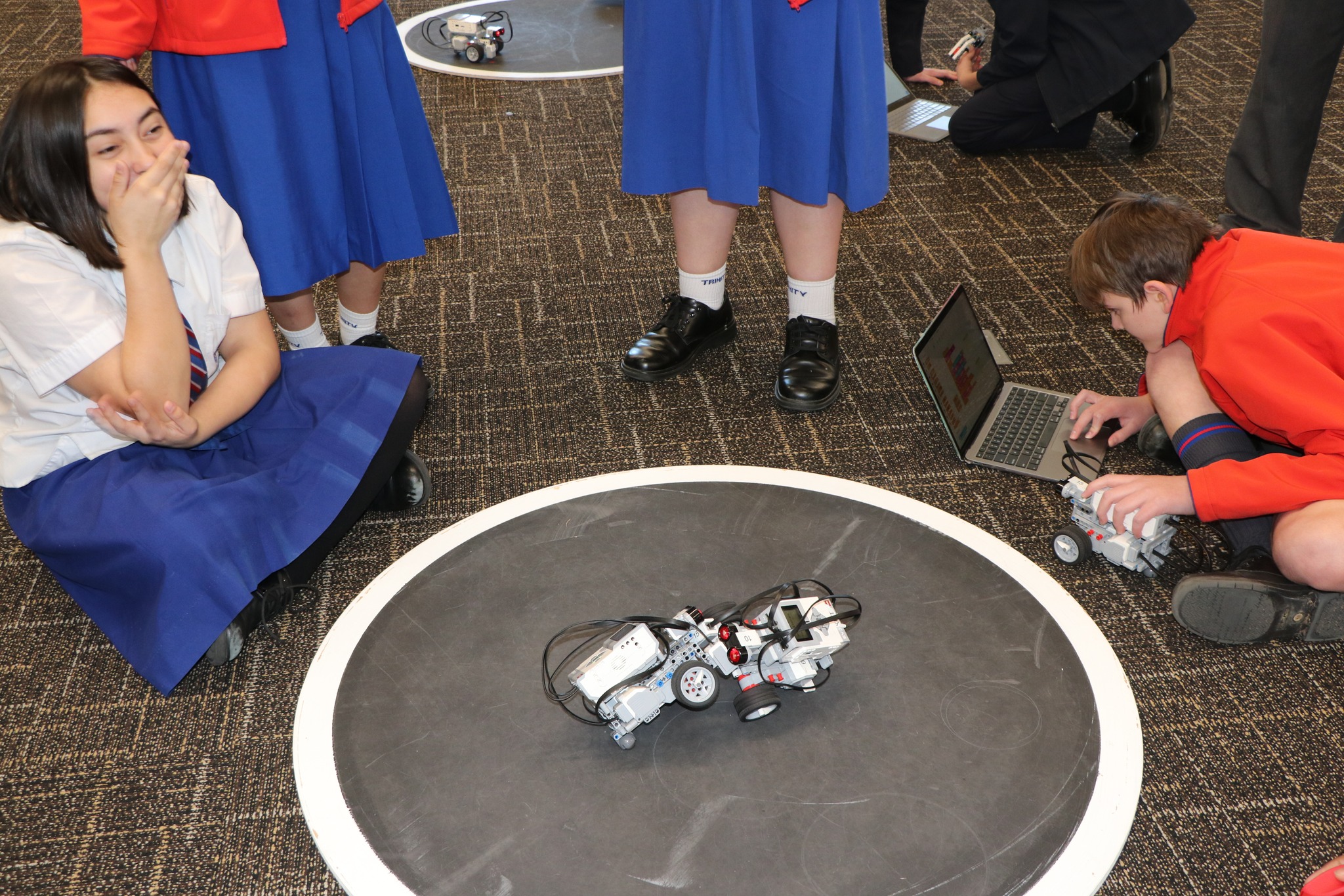 Students testing and coding robots on a competition platform promoting teamwork critical thinking and hands on robotics learning