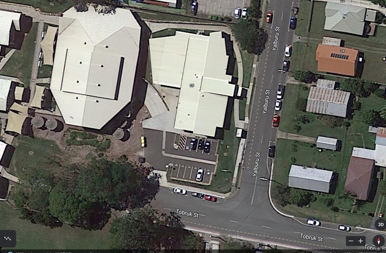Aerial view of school buildings and surrounding streets providing location context and campus layout within the local community