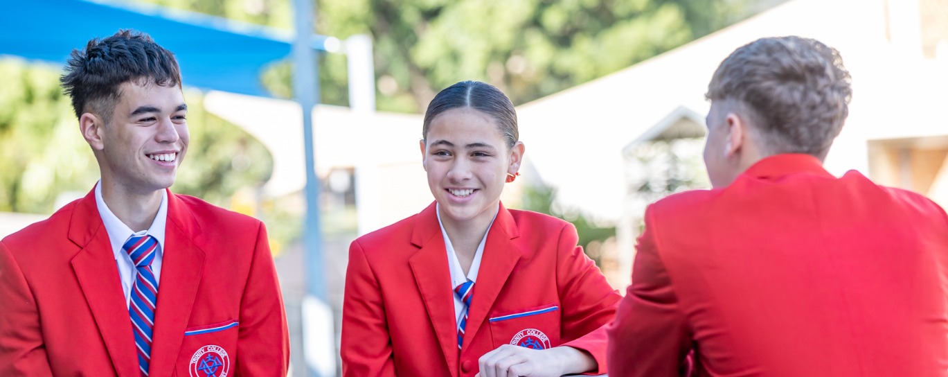 Students in school uniform at Trinity College Beenleigh connecting outdoors and representing community belonging and school pride